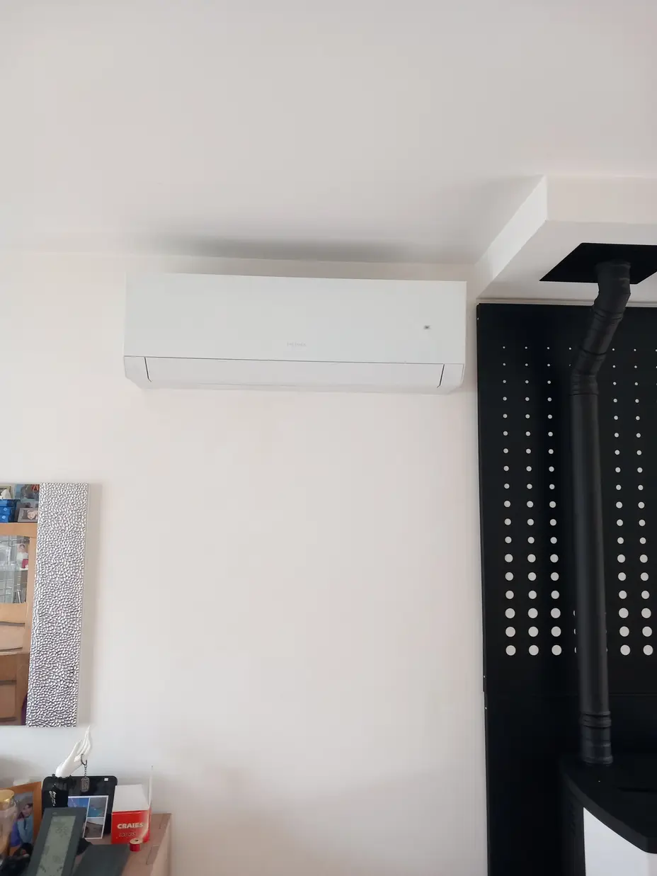 Climatisation réversible Heiwa installée en haut d'un mur dans un séjour à Verneuil-sur-Seine (78)