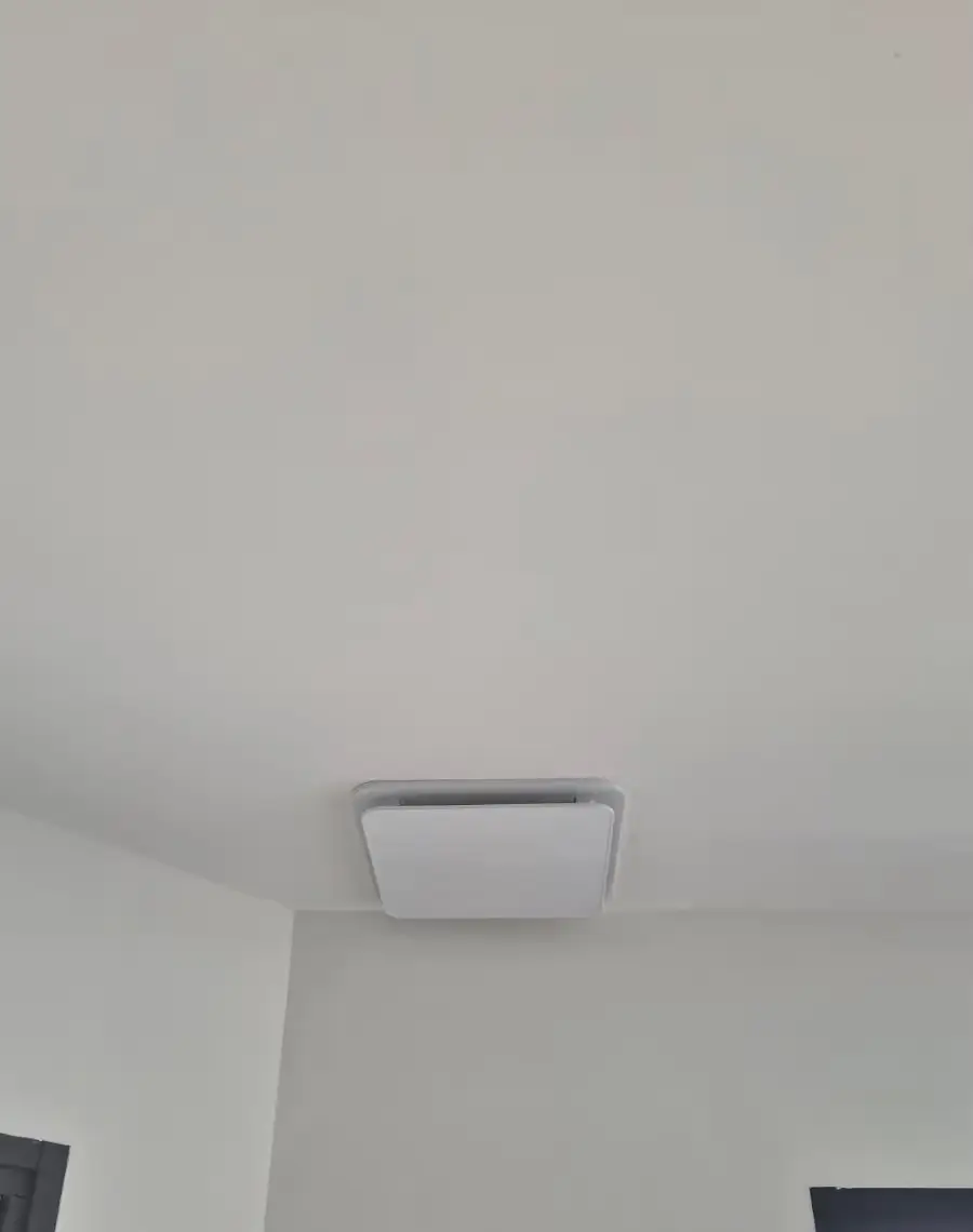 Bouche de soufflage d'une climatisation gainable encastrée en haut d'un mur à Médan (78)