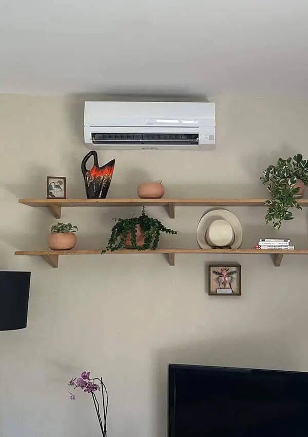 Climatiseur mural Mitsubishi Electric mono-split posé au-dessus d'étagères à Poissy (78)